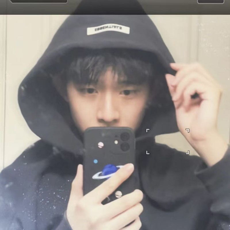 Eric taking a mirror selfie in a black hoodie